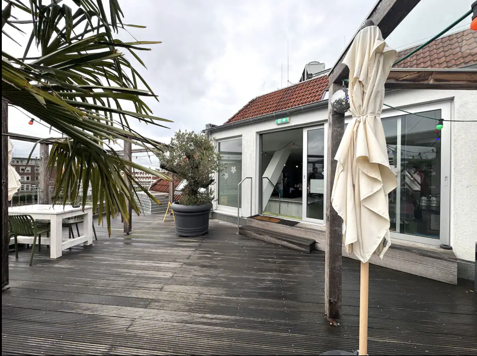 Holzdeck der Dachterrasse mit Loungemöbeln in der Nachmittagssonne